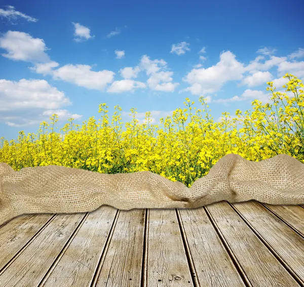 Lege houten tafel met bloemen en hemel — Stockfoto