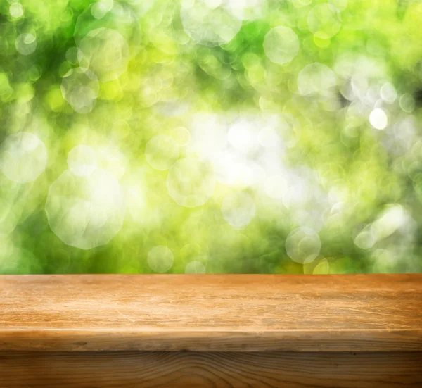 空の木製テーブルとグリーンのボケ味の泡 — ストック写真