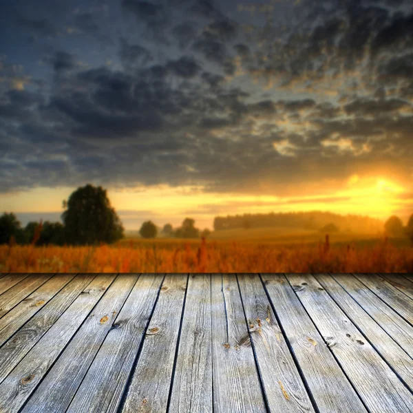 Leerer Holztisch und defokussierte Sonnenuntergangslandschaft — Stockfoto