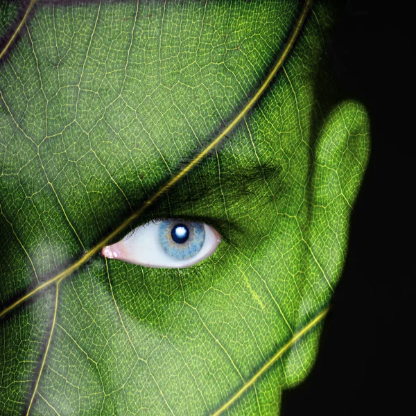 Mänskligt ansikte täckt med grönt blad konsistens — Stockfoto