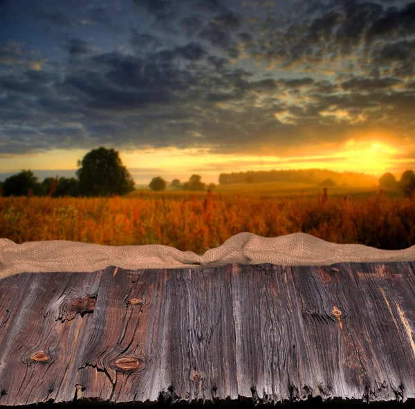 Empty wooden table and defocused sunset landscape — Stock Photo, Image