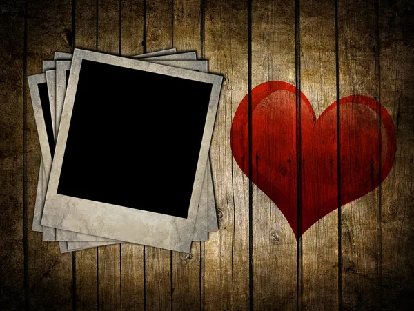 Wooden background with photo frames and heart — Stock Photo, Image