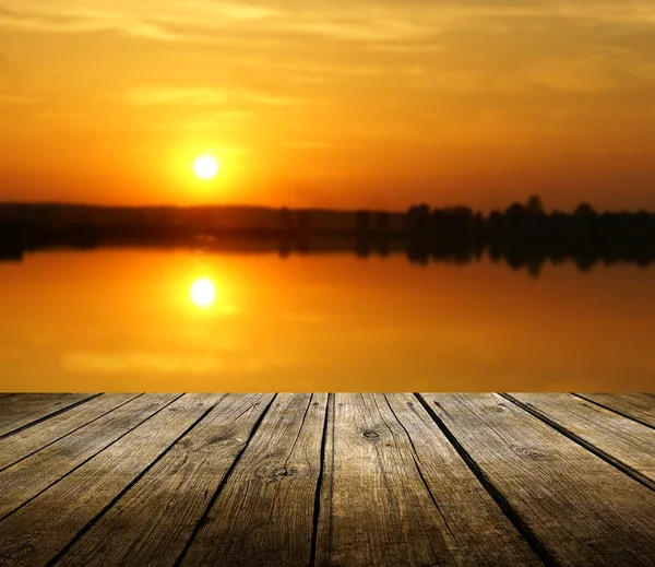 Lege houten dek tabel met zonsondergang op achtergrond — Stockfoto