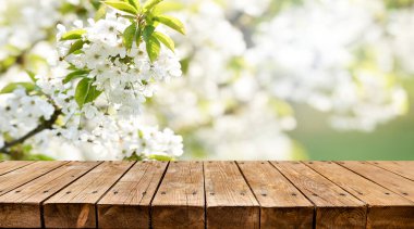 Arka planda bahar çiçekleri olan boş ahşap masa