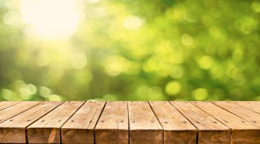 Arka planda taze yeşil baharı olan boş eski ahşap masa.