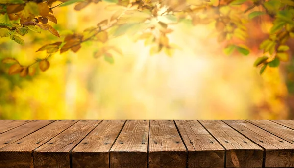 秋の背景を持つ空の古い木製のテーブル — ストック写真