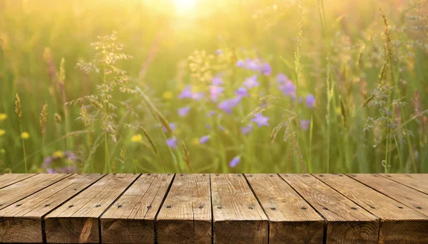 Empty old wooden table with meadow in background