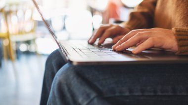 Laptop bilgisayarında çalışan ve daktilo yazan bir kadının yakın plan resmi
