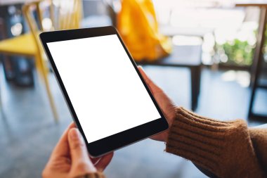 Boş beyaz masaüstü ekran ile siyah tablet bilgisayarını tutan bir kadının görüntüsü 