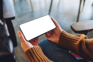 Boş masaüstü ekran ile siyah cep telefonu tutan bir kadının görüntüsü 