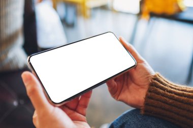 Boş masaüstü ekran ile siyah cep telefonu tutan bir kadının görüntüsü 