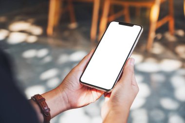 Boş masaüstü ekranı olan siyah cep telefonunu tutan ellerin görüntüsü