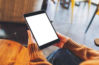 Boş beyaz masaüstü ekran ile siyah tablet bilgisayarını tutan bir kadının görüntüsü 