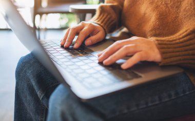 Laptop bilgisayarında çalışan ve daktilo yazan bir kadının yakın plan resmi