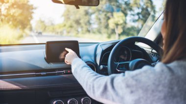 Yakından bakınca güzel bir kadın araba sürerken navigasyon ekranını kullanıyor ve işaret ediyor.