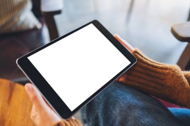Boş beyaz masaüstü ekran ile siyah tablet bilgisayarını tutan bir kadının görüntüsü 
