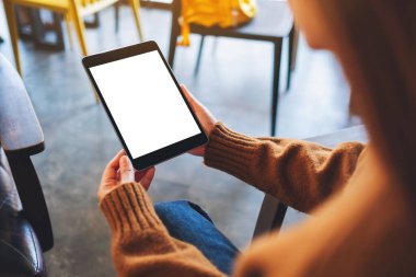 Boş beyaz masaüstü ekran ile siyah tablet bilgisayarını tutan bir kadının görüntüsü 