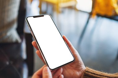 Boş masaüstü ekran ile siyah cep telefonu tutan bir kadının görüntüsü 