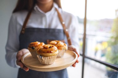 Bir garson elinde tahtadan bir tabak Danimarka üzümü tutuyor. 