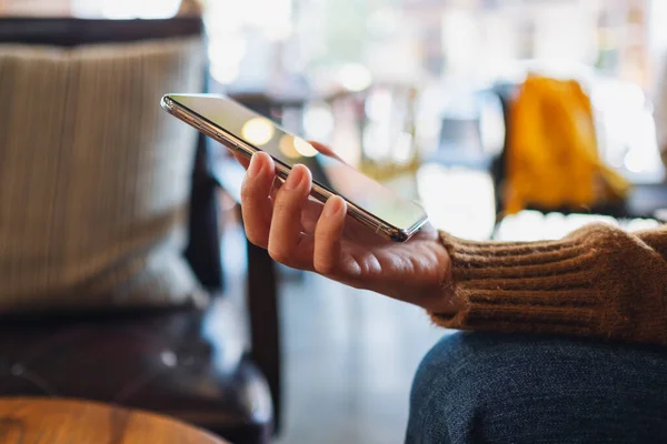 Cep telefonu tutan ve kullanan bir kadının yakın plan görüntüsü