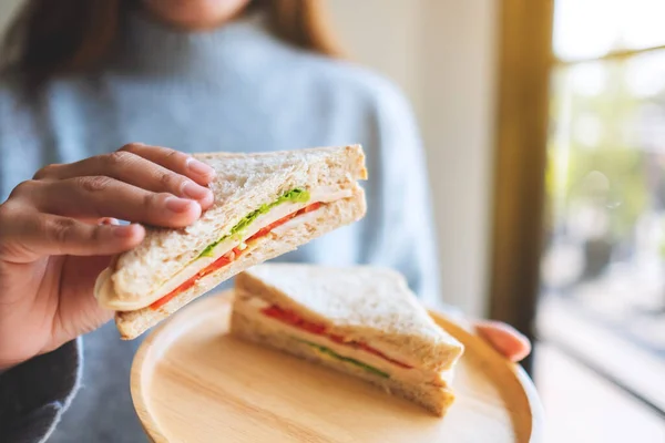 Imagen Una Mujer Sosteniendo Comiendo Sándwich Trigo Entero Plato Madera —  Fotos de Stock