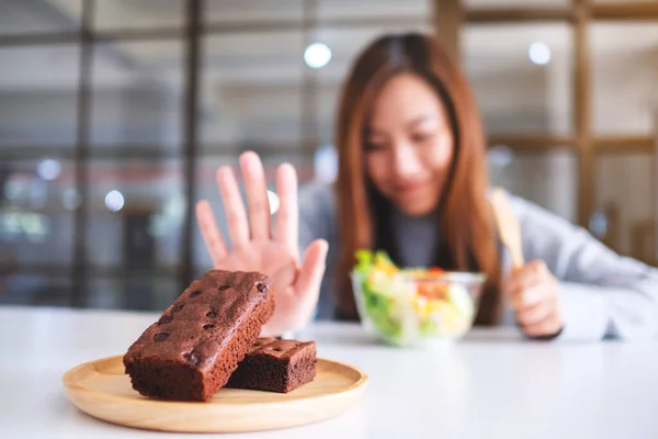Een Vrouw Die Kiest Groentesalade Eten Handtekenen Maakt Een Brownie — Stockfoto