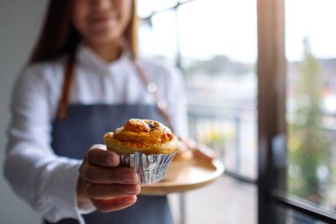 Bir garson kucağında bir parça kurabiye veriyor. 