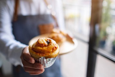 Bir garson kucağında bir parça kurabiye veriyor. 