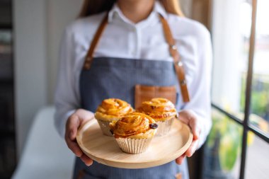 Bir garson elinde tahtadan bir tabak Danimarka üzümü tutuyor. 