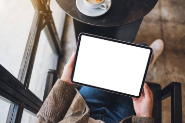 Siyah tabletli beyaz ekranlı bir kadının üst görünüm görüntüsü 