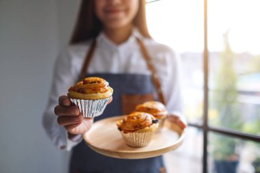 Bir garson elinde tahtadan bir tabak Danimarka üzümü tutuyor. 