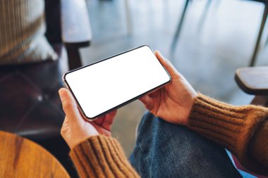 Boş masaüstü ekran ile siyah cep telefonu tutan bir kadının görüntüsü 