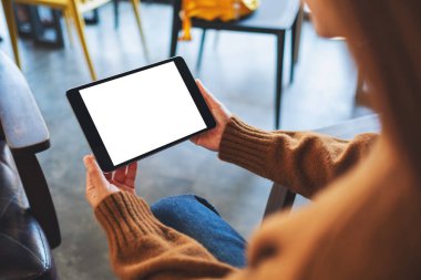 Boş beyaz masaüstü ekran ile siyah tablet bilgisayarını tutan bir kadının görüntüsü 