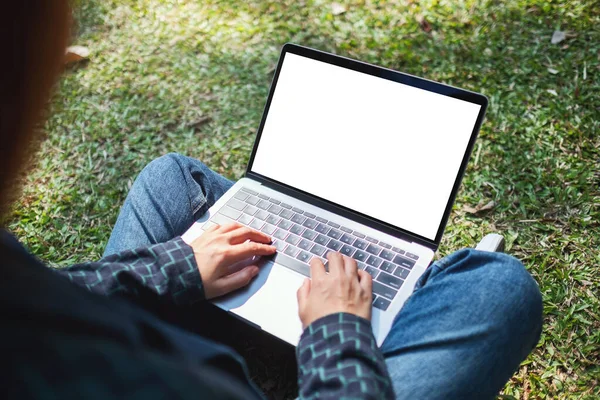 Bir kadının laptopta boş beyaz ekranla yazarken ve kullanırken çekilmiş görüntüsü.
