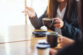 Detailní záběr na lidi, kteří spolu rádi mluví a pijí kávu v kavárně
