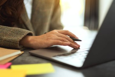İş kadını dizüstü bilgisayarında ofis masasında kağıt işleriyle daktilo kullanıyor.