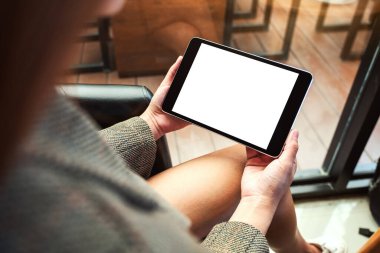 Boş beyaz masaüstü ekran ile siyah tablet bilgisayarını tutan bir kadının görüntüsü 