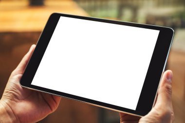 Boş beyaz masaüstü ekran ile siyah tablet bilgisayarını tutan bir kadının görüntüsü 