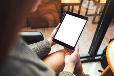 Boş beyaz masaüstü ekran ile siyah tablet bilgisayarını tutan bir kadının görüntüsü 