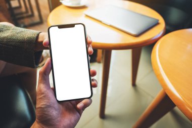 Boş beyaz masaüstü ekran ile cep telefonunu tutan ve gösteren bir kadının görüntüsü