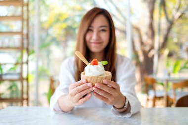 Restoranda dondurma yiyen Asyalı güzel bir kadının yakın plan görüntüsü.