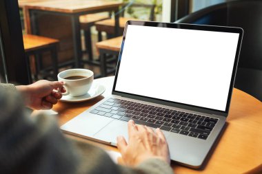 Kahve içerken bilgisayardaki dokunmatik dokunmatik dokunmatik ekranlı boş beyaz masaüstü ekranlı bir kadının görüntüsü.