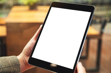 Boş beyaz masaüstü ekran ile siyah tablet bilgisayarını tutan bir kadının görüntüsü 