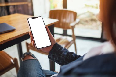 Siyah cep telefonunu boş ekran ile tutan bir kadının görüntüsü. 