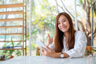 Cafe 'de cep telefonu kullanırken güzel bir Asyalının el işareti yaparken yakın plan görüntüsü