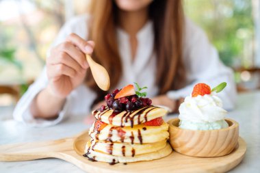 Karışık böğürtlenli krep yiyen bir kadın. Dondurma ve çırpılmış krema.