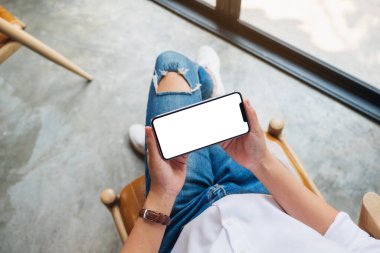 Üst görünüm görüntüsü boş beyaz ekranlı cep telefonu tutan bir kadının görüntüsü 