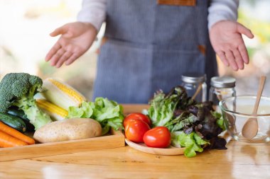 Mutfakta pişirecek taze sebzeleri gösteren ve hazırlayan bir kadın şefin yakın plan görüntüsü.