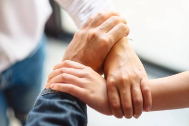 İnsanlar birlik ve takım çalışması konsepti için ellerini bir çemberin içine sokuyorlar.