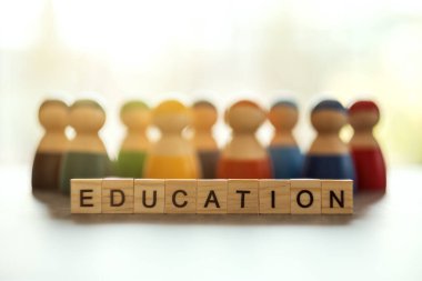 Tahta bloklar ve arka planda bir grup insan hakkında eğitim kelimesi